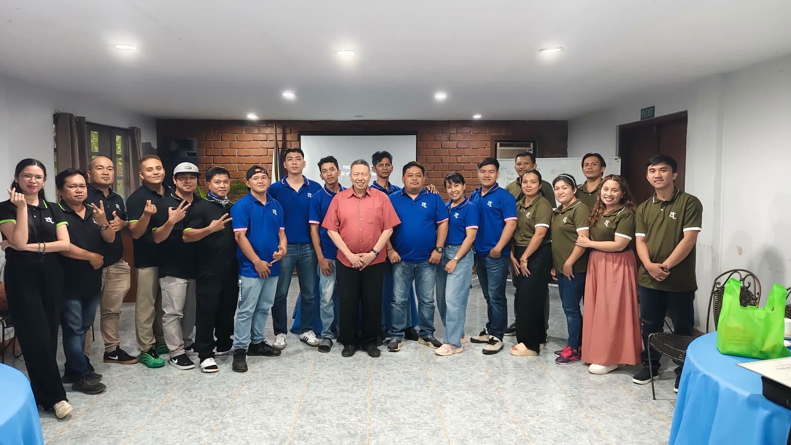 The full Banexco staff in company polos gathered with the company president for a group photo in Davao City